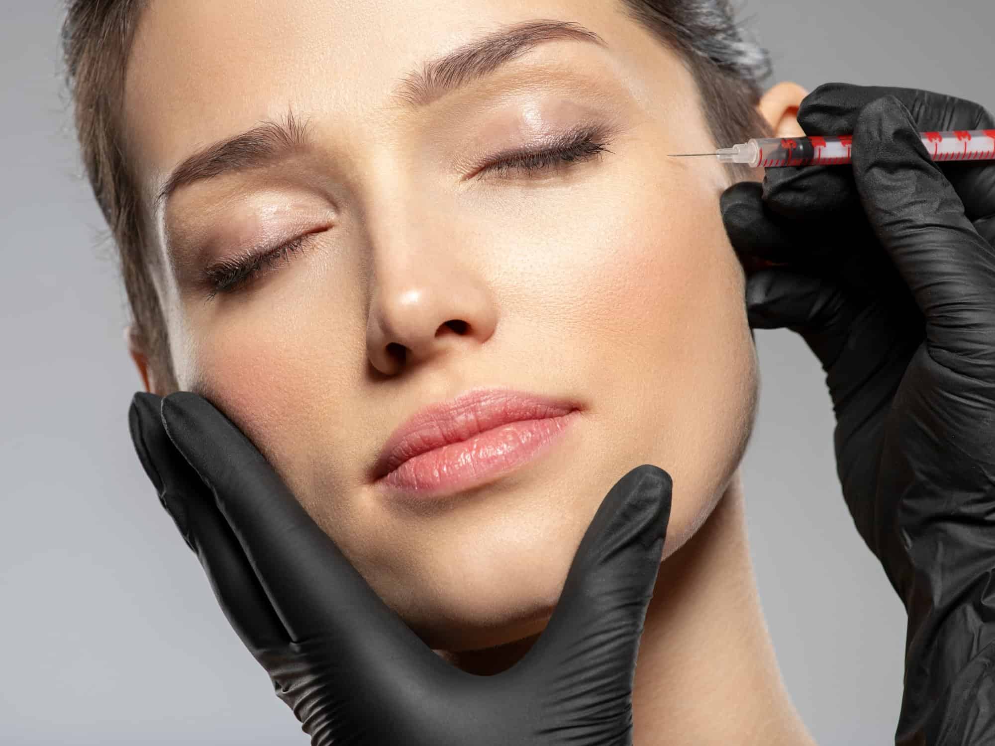 Caucasian woman getting botox cosmetic injection in forehead. Woman gets botox injection in her face