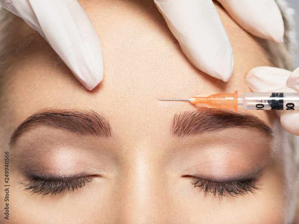 A person being injected between the eyebrows with skin treatment