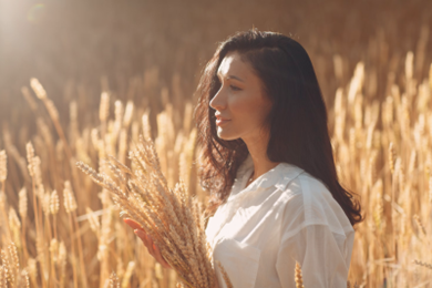 Woman standing in an Autumn field with glistening skin from Skin Savvy’s skin rejuvenation.