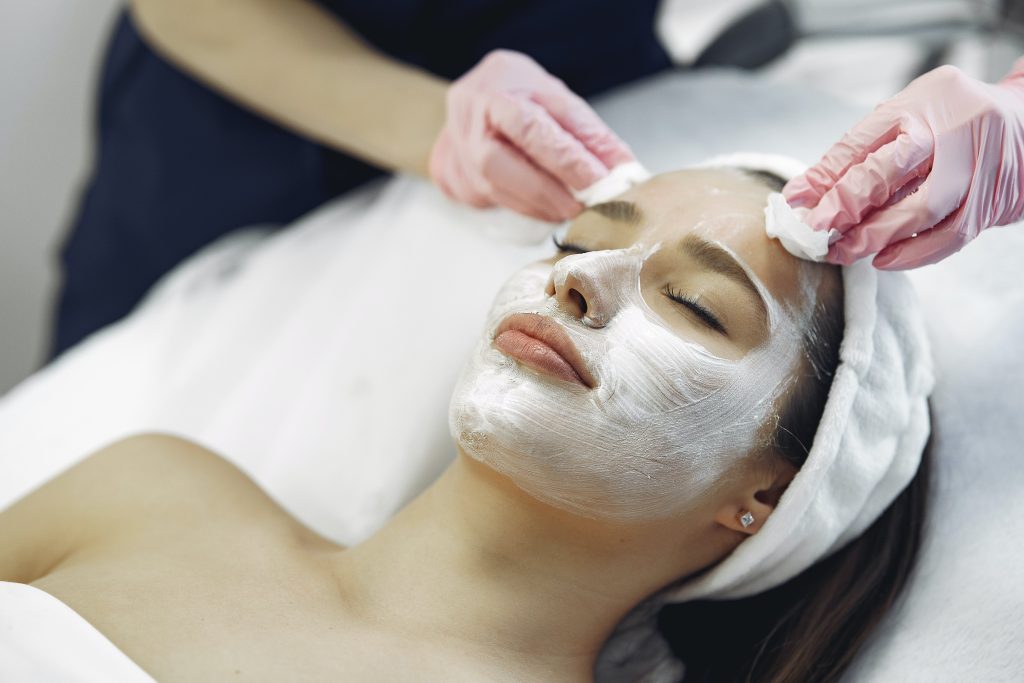 Woman relaxing while receiving a cosmetic mask treatment at a spa